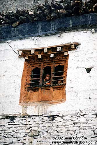 Children peeking down from a window. -- Kagbeni, Nepal